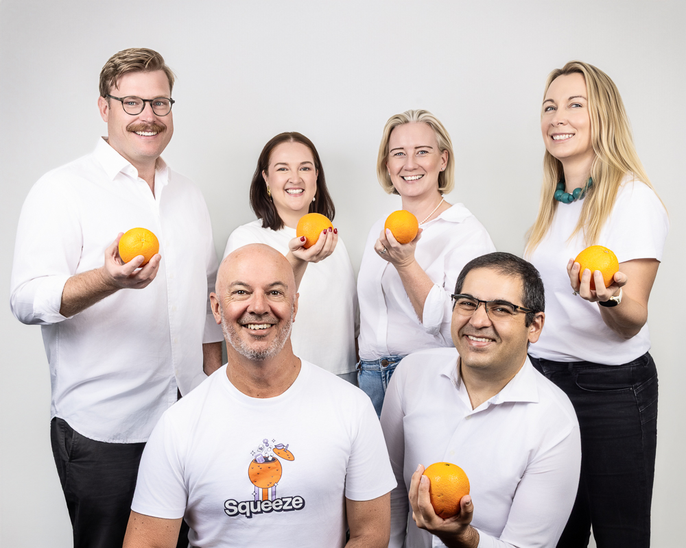 team photo holding oranges 